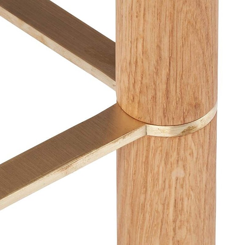 Brass foot rail around an oak leg on the Emilia bar stool