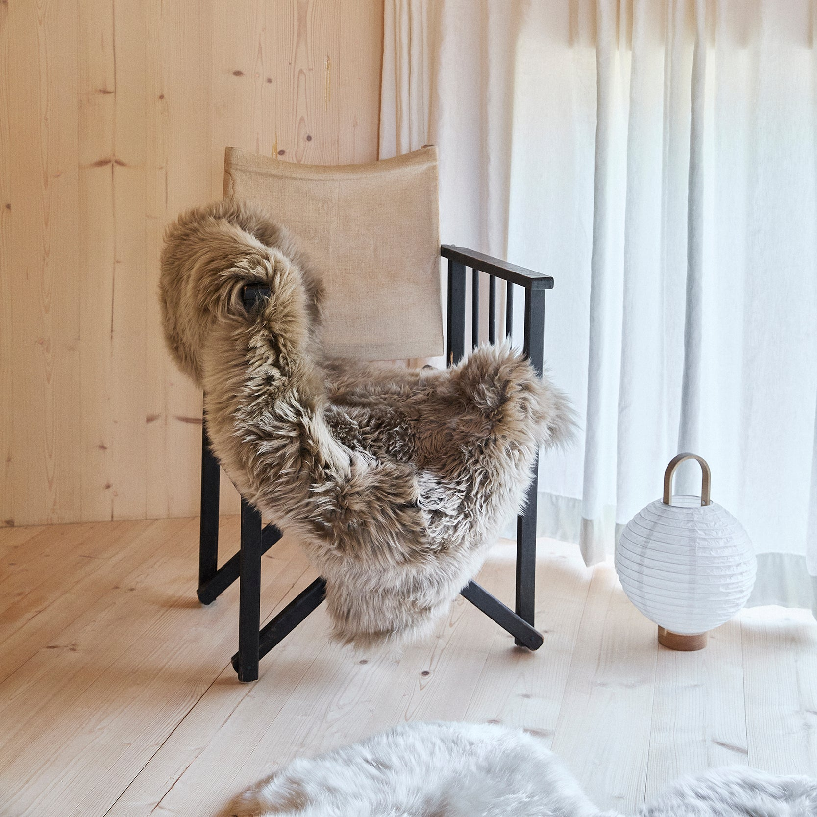Cream single sheepskin draped over a wooden bench