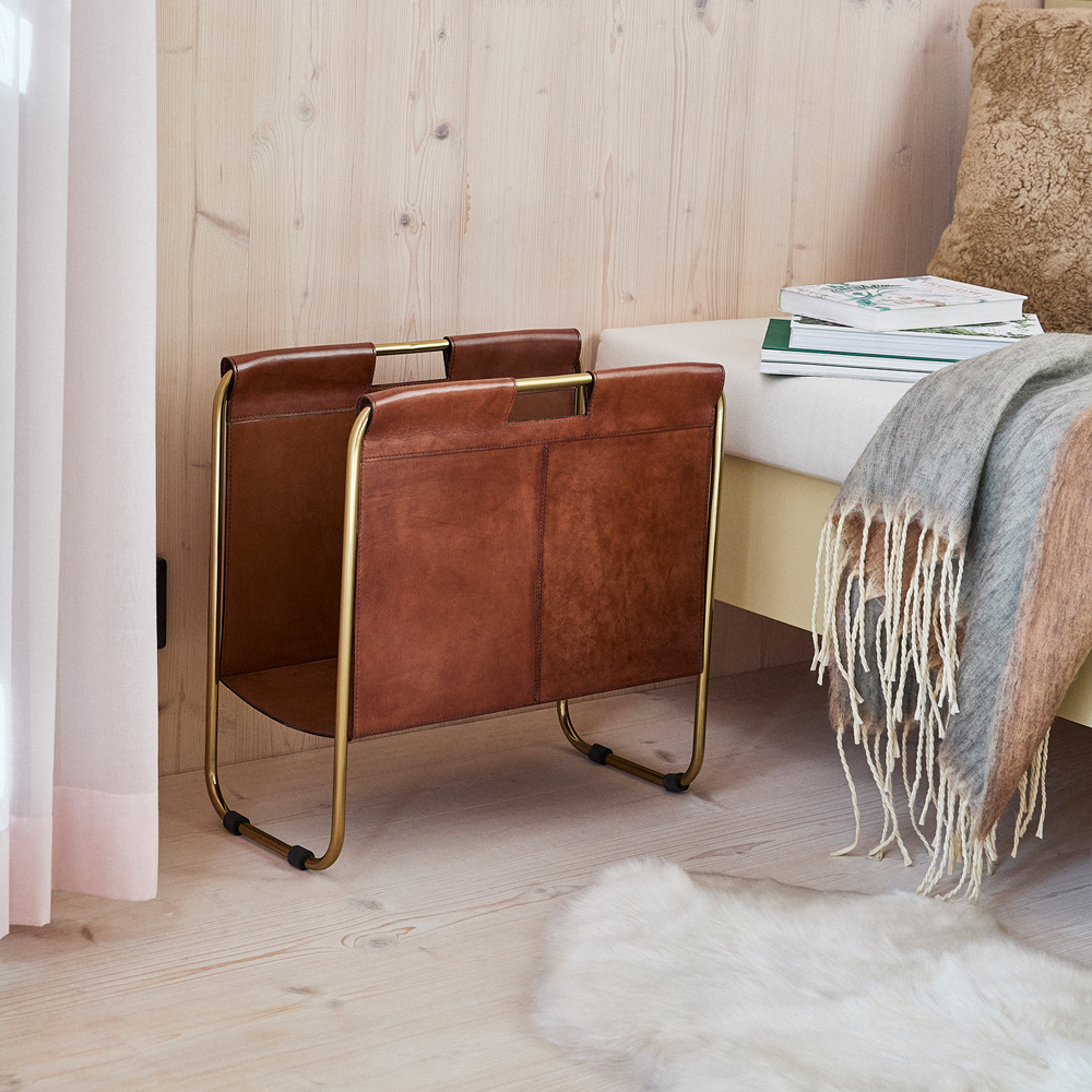 Leather magazine holder beside a sheepskin rug