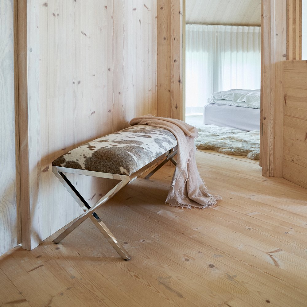 Cowhide bench in a bright wooden bedroom