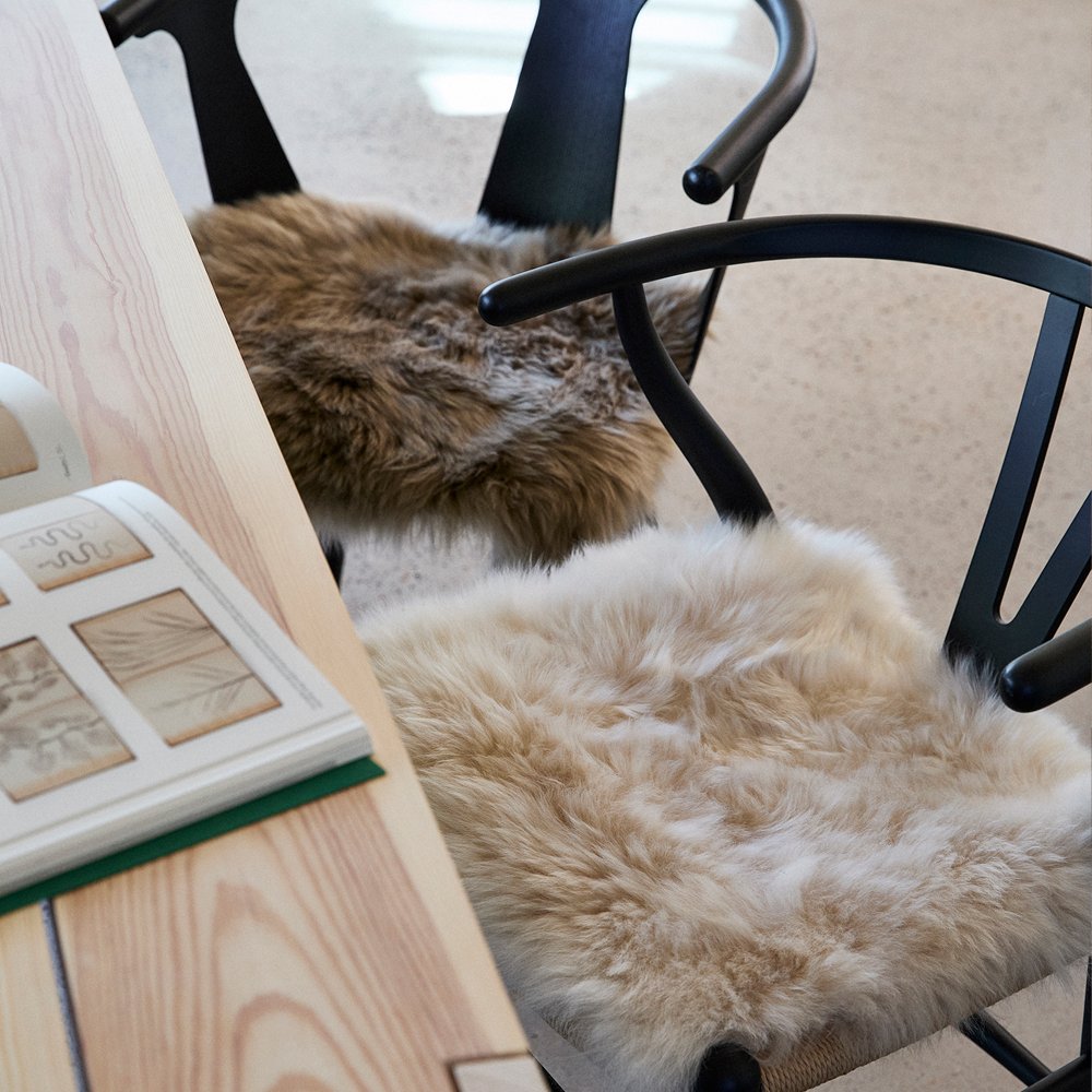 Sheepskin seat covers on wooden chairs
