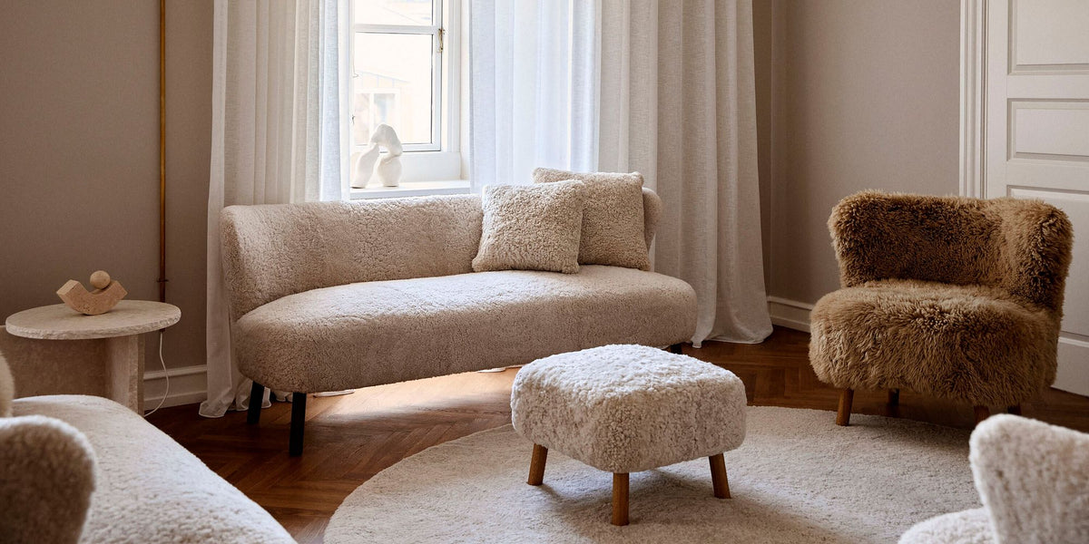 Living room with a pearl sheepskin sofa and foot rest and an Emily lounge chair in honey long hair