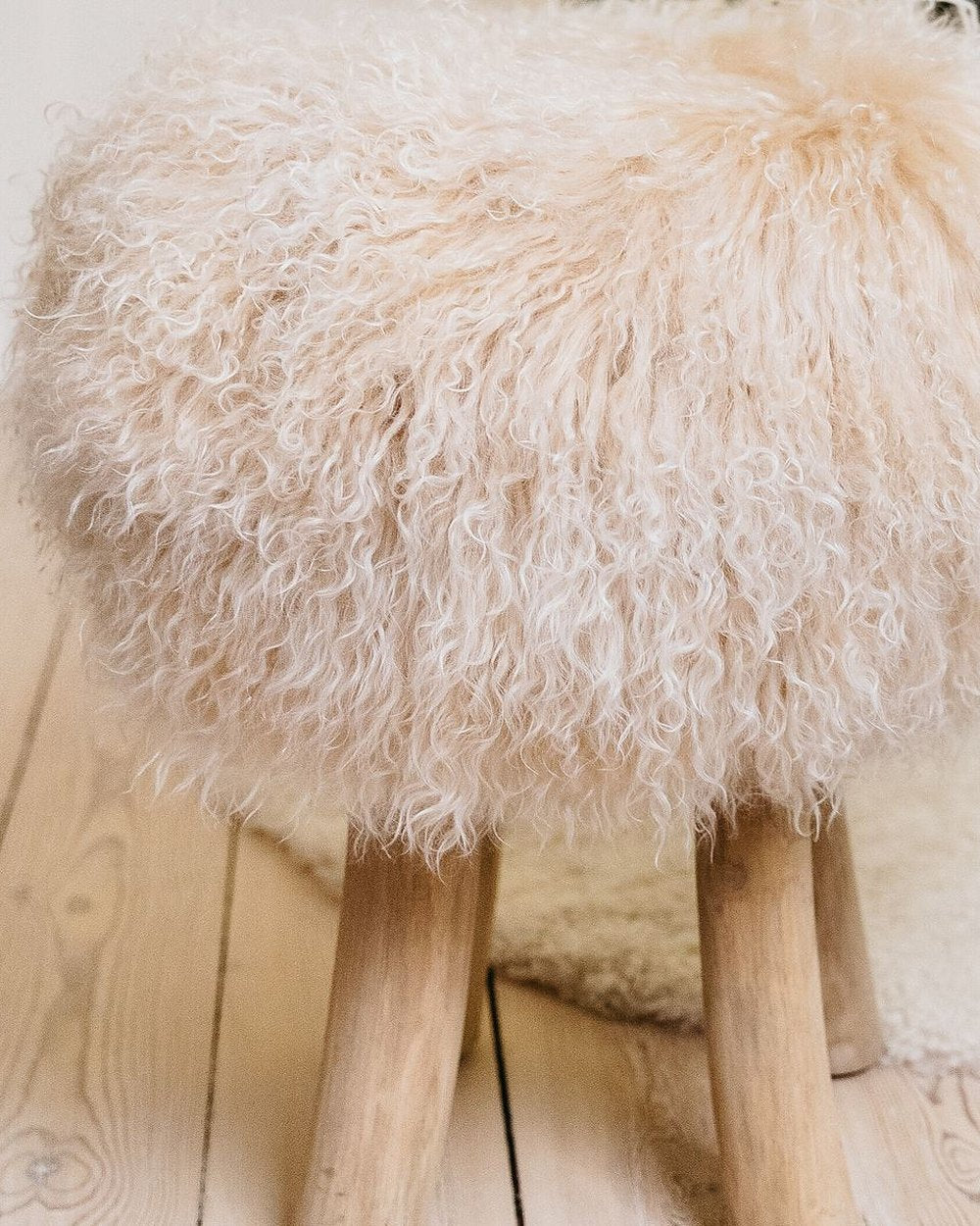 Theo stool with a cream Tibetan curly cover with a soft peach blush