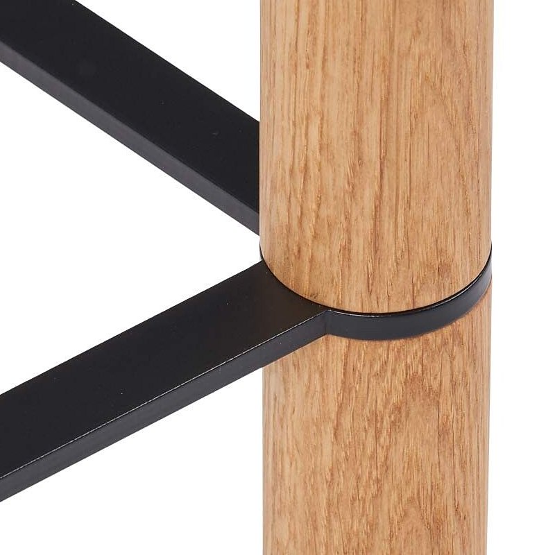 Black steel foot rail around an oak leg on the Emilia bar stool