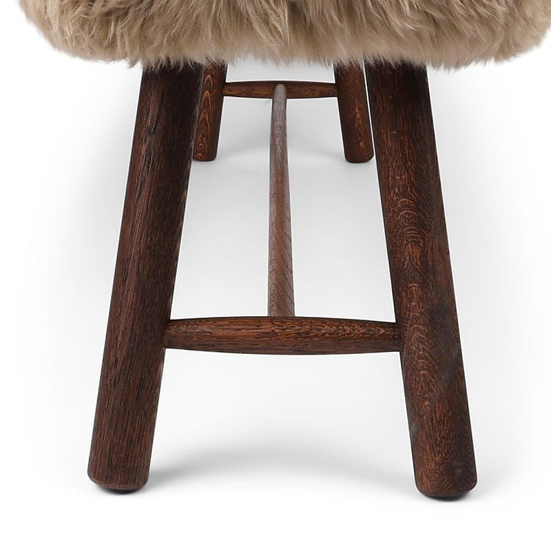 End view of the Theo bench with dark oiled oak legs under taupe long hair