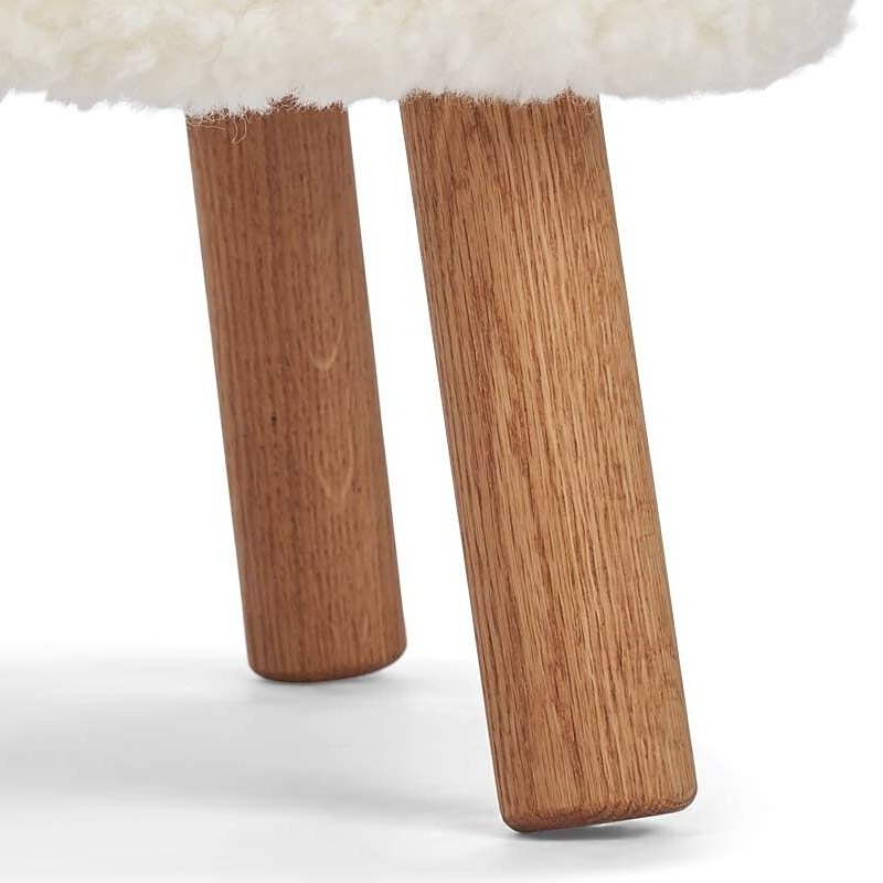 Detail of two natural oak legs under an ivory short hair seat