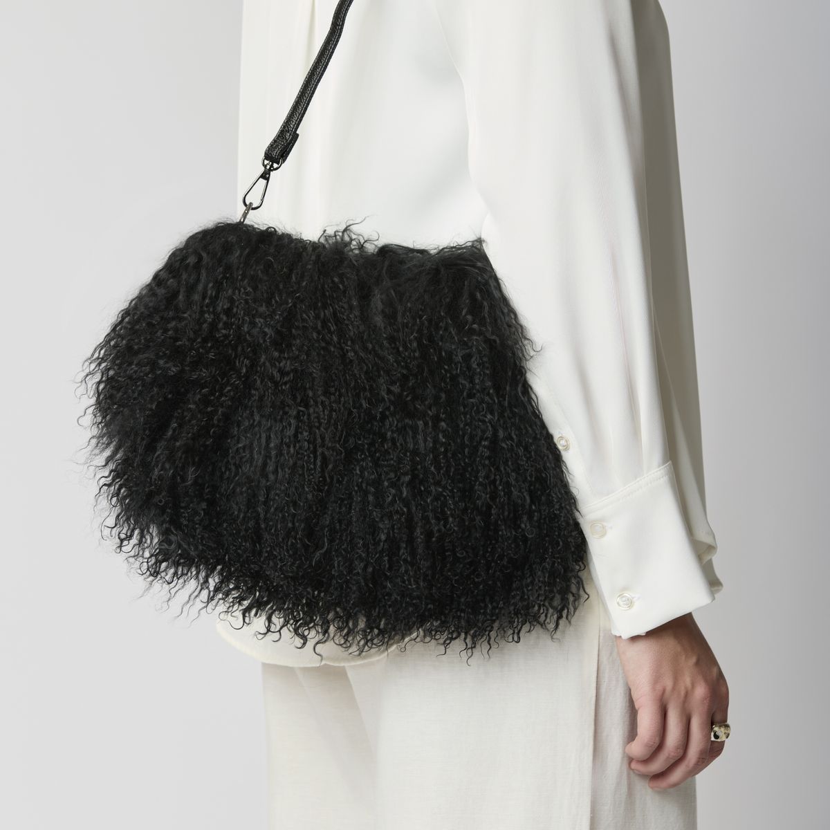 Black curly sheepskin bag on a shoulder strap